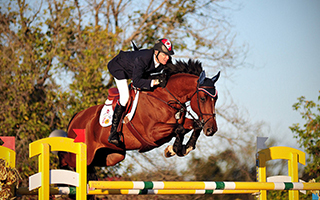 Ian Millar, athlète canadien en sports équestres, et son cheval sautent un obstacle durant une compétitio